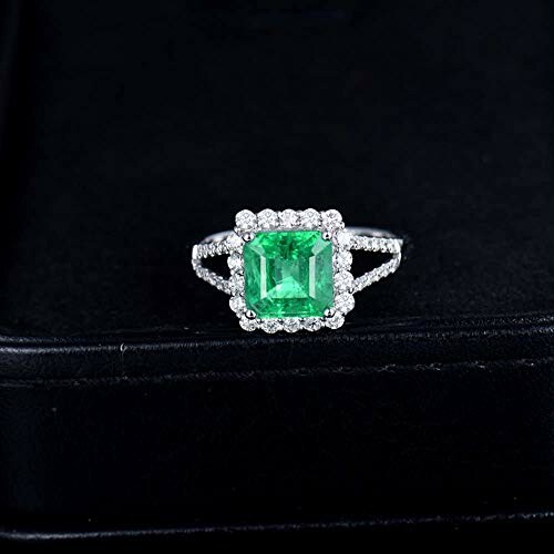 Emerald and diamond ring on black background